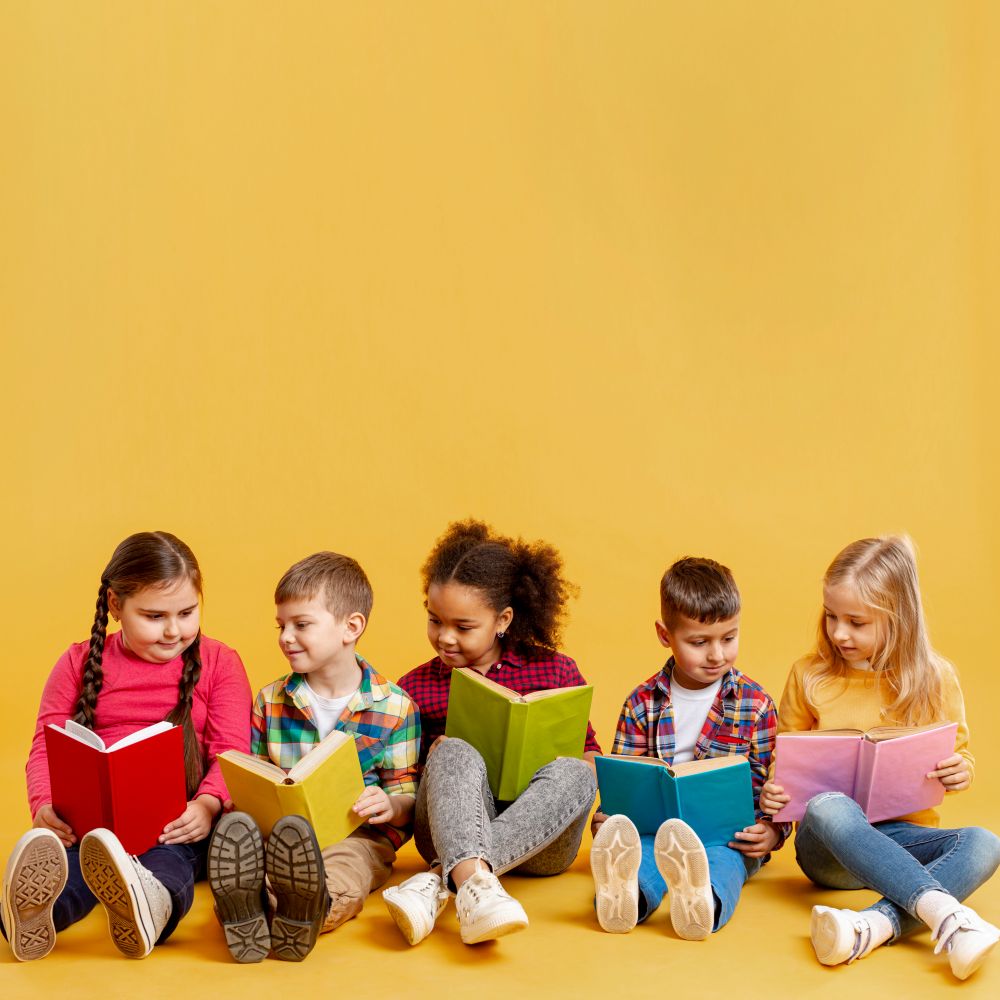 children reading books sitting next to each other